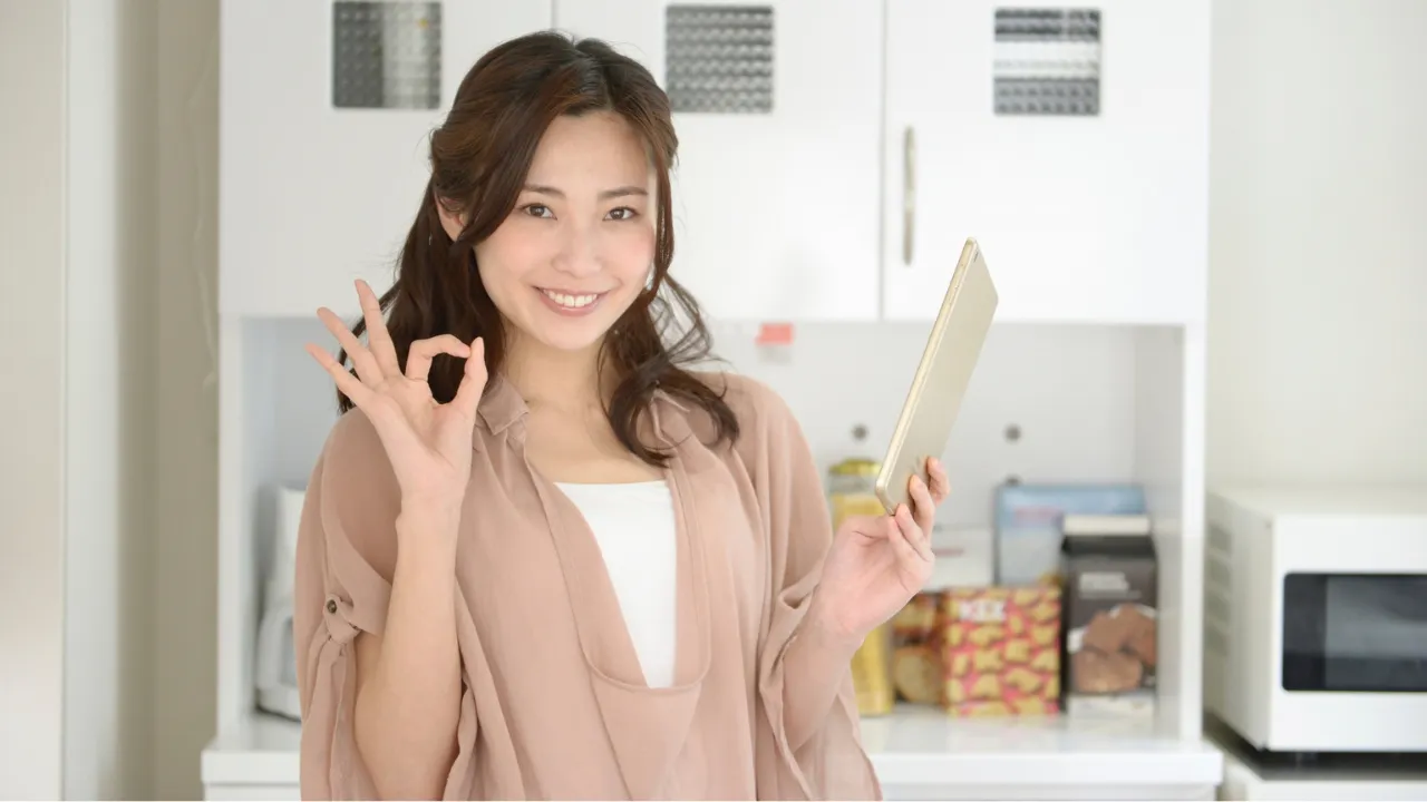 電卓や家計簿を使って家計管理をしている笑顔の女性