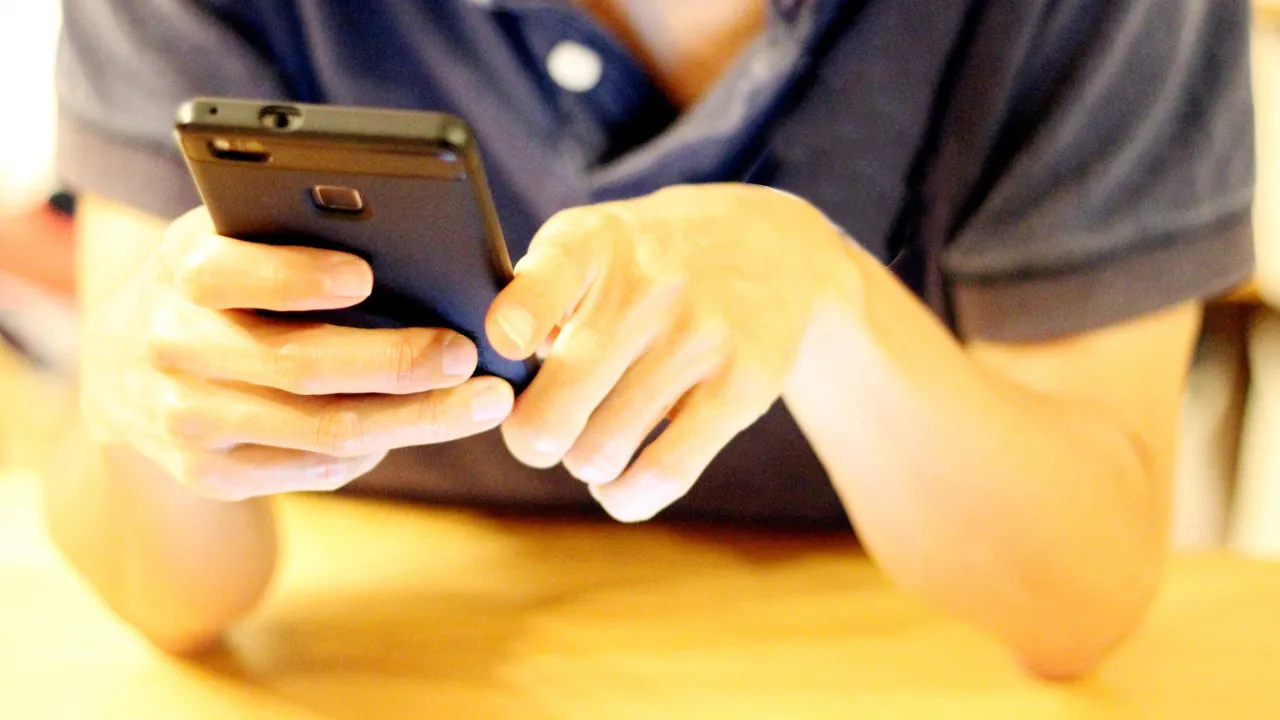 LINEを操作する30代男性の手元