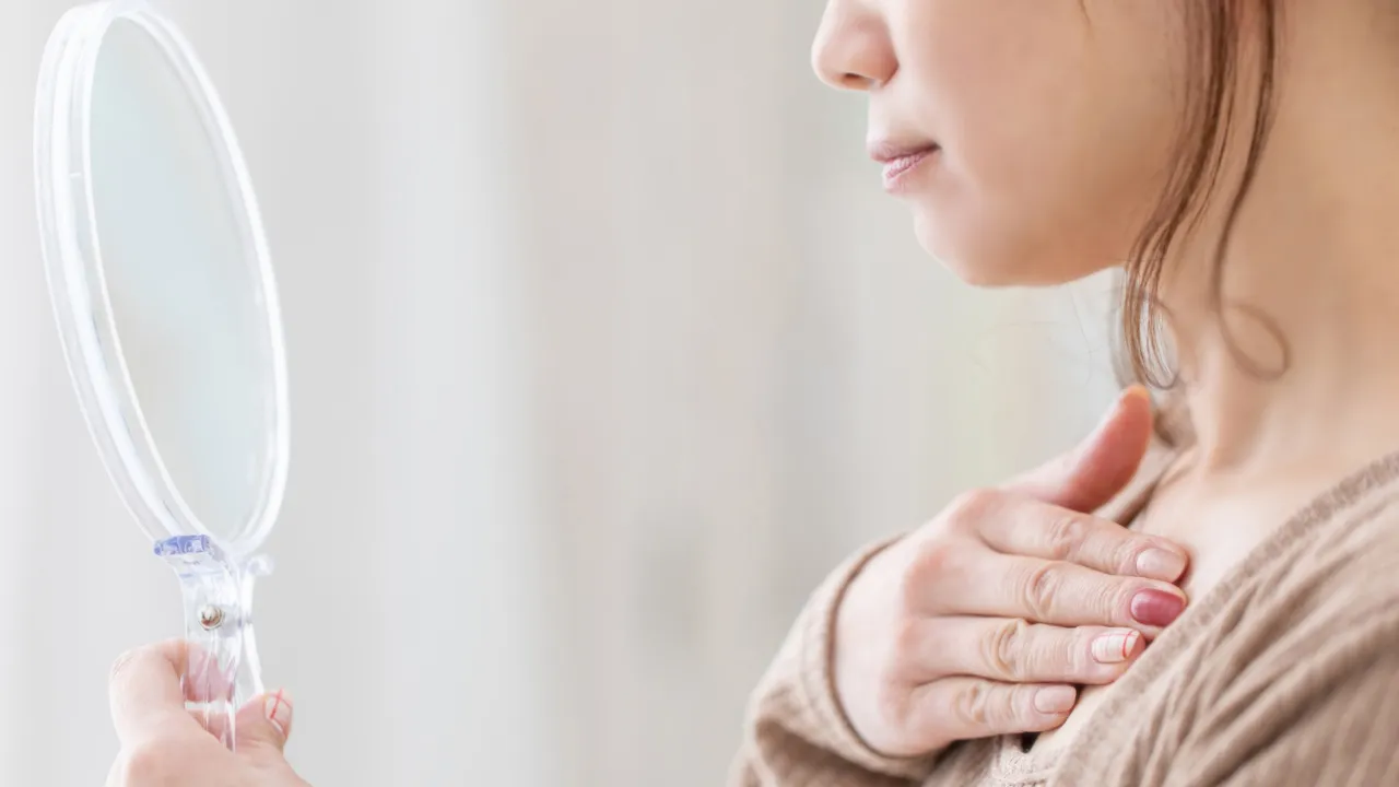 鏡を見ながら自分に向き合う女性の手元と表情