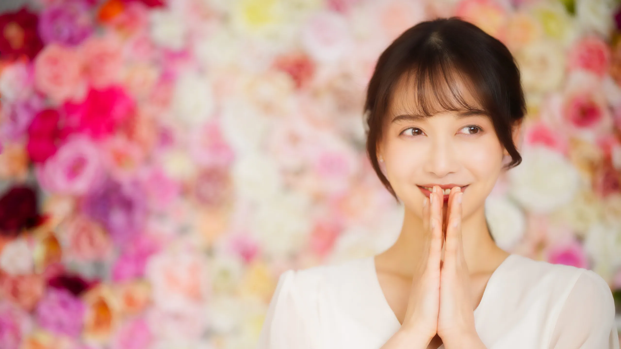花の前で微笑むモテる女子のイメージ写真