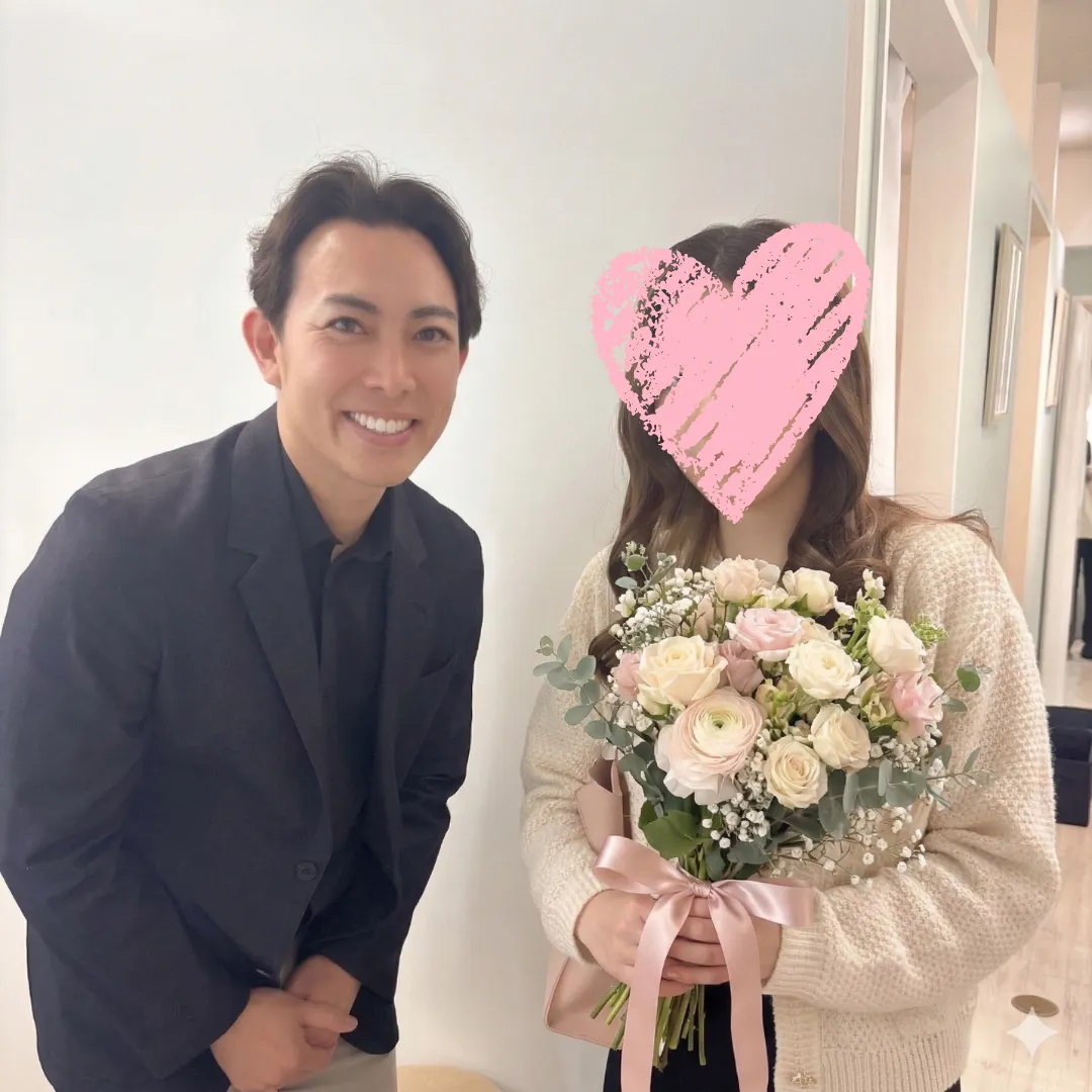 川越の結婚相談所Sweet Colorで、カウンセラー藍辰徳が成婚退会者の女性を花束でお祝いしている写真